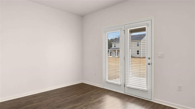 spare room with dark wood-style floors and baseboards