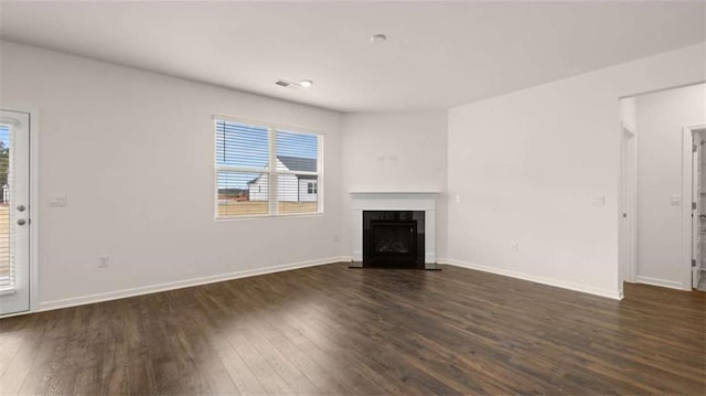 unfurnished living room with baseboards, a fireplace with flush hearth, and dark wood-type flooring