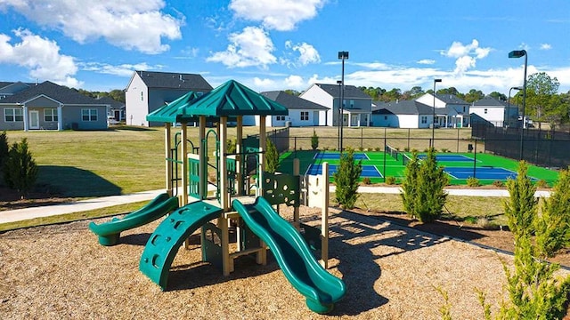 community playground featuring a yard, a residential view, and fence