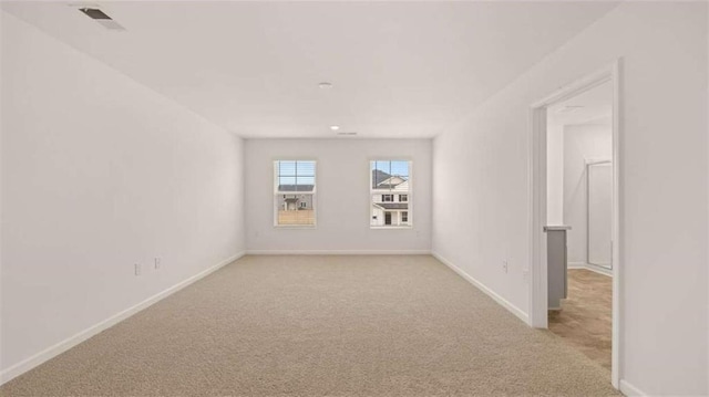 empty room with visible vents, light colored carpet, and baseboards