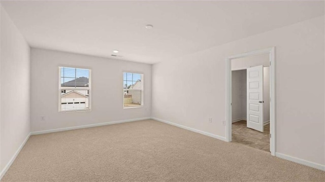 carpeted empty room featuring baseboards