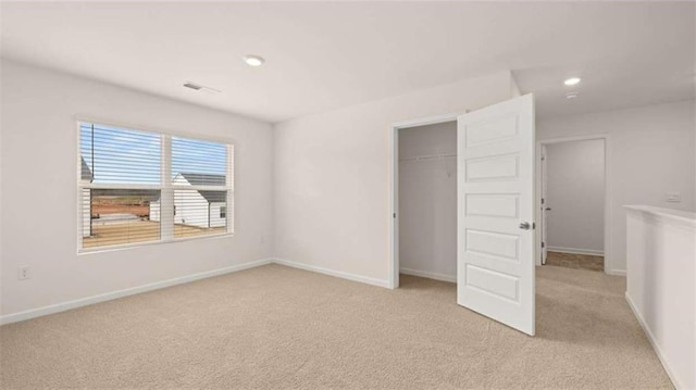 unfurnished bedroom with visible vents, baseboards, recessed lighting, a closet, and light carpet