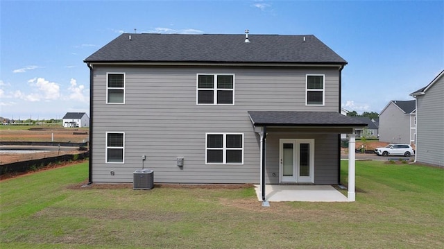 back of house with a shingled roof, central air condition unit, french doors, a yard, and a patio