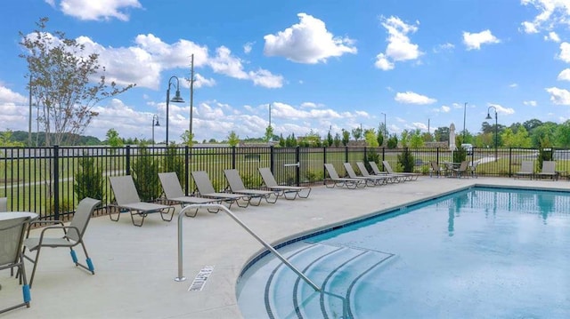 community pool featuring a patio and fence