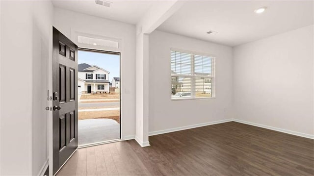 foyer featuring visible vents, baseboards, and dark wood finished floors