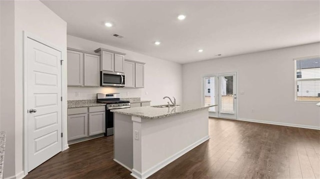 kitchen with dark wood finished floors, gray cabinets, appliances with stainless steel finishes, and a sink