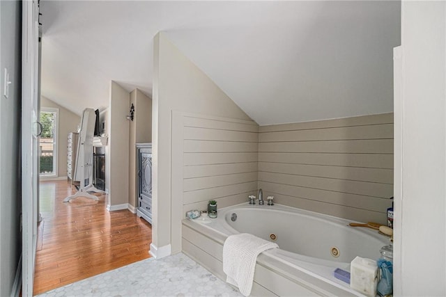 614 Cooledge Ave NE, Atlanta, GA 30306 - bathroom featuring vaulted ceiling, a whirlpool tub, and baseboards
