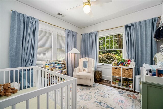 614 Cooledge Ave NE, Atlanta, GA 30306 - bedroom with a crib, wood finished floors, and ceiling fan