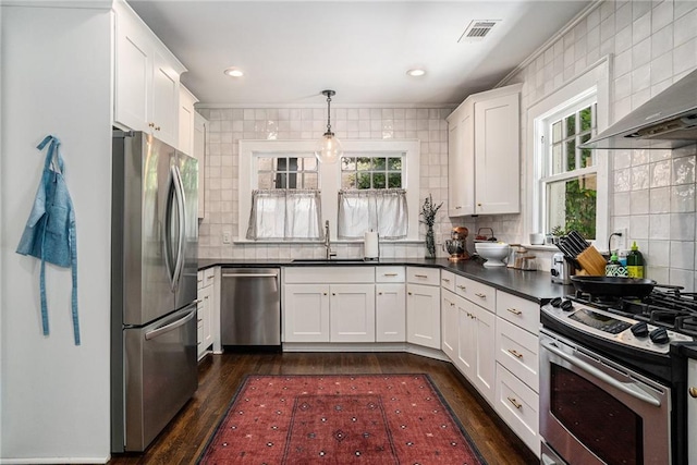 614 Cooledge Ave NE, Atlanta, GA 30306 - kitchen featuring appliances with stainless steel finishes, wall chimney range hood, a sink, dark countertops, and tasteful backsplash