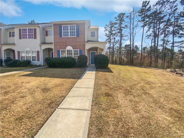 view of front of home with a front yard and brick siding