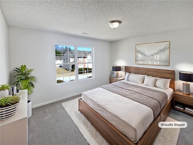 carpeted bedroom featuring baseboards and a textured ceiling