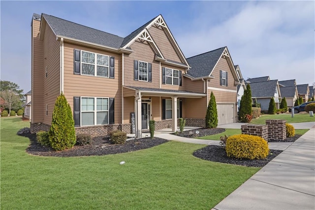 craftsman house featuring a front yard, an attached garage, brick siding, and driveway