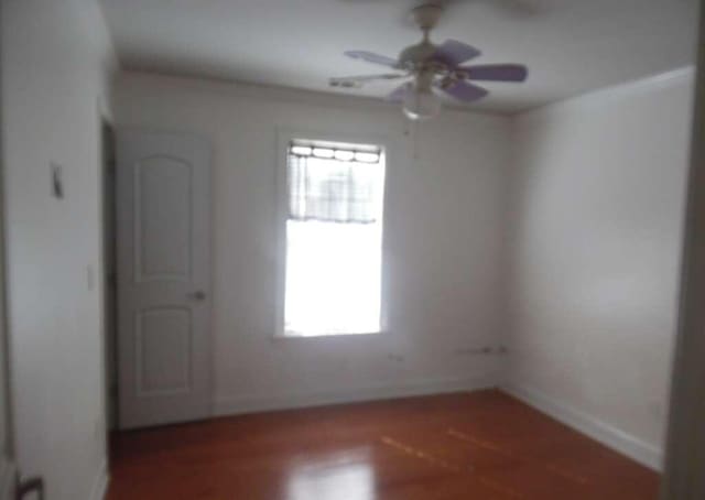 empty room with dark hardwood / wood-style flooring and ceiling fan