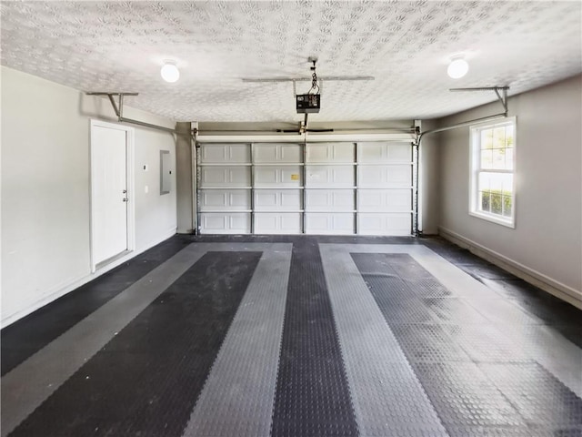 garage with a garage door opener, baseboards, and electric panel