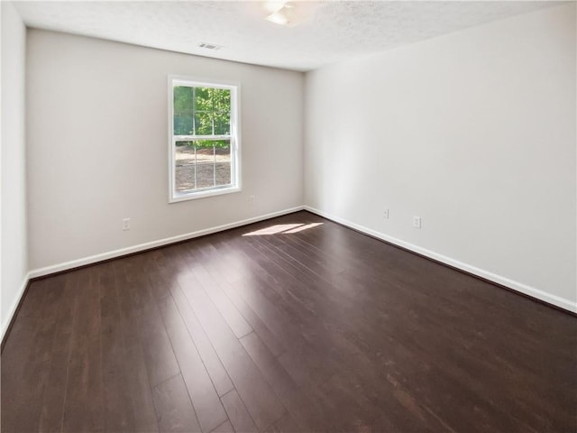 unfurnished room featuring dark wood-style floors and baseboards