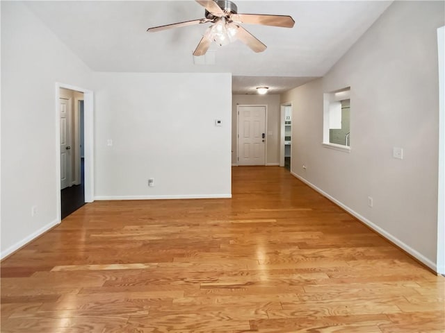 unfurnished room with ceiling fan, baseboards, and light wood-style flooring