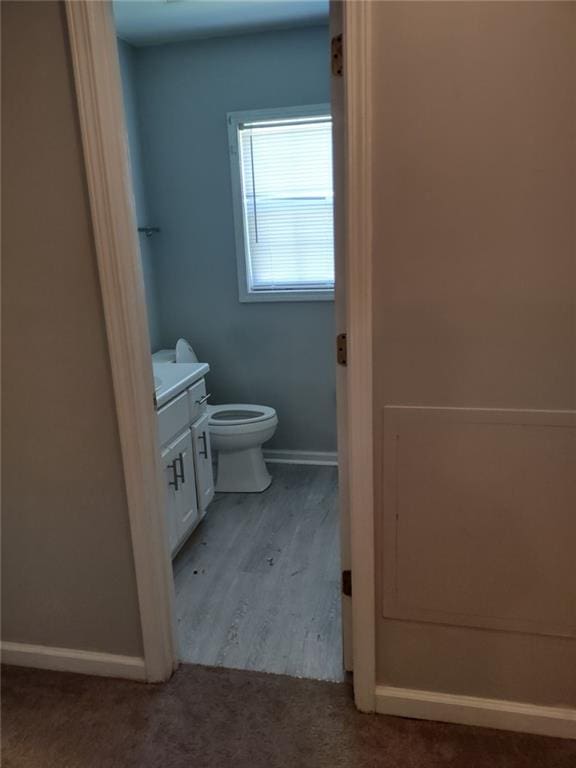 bathroom featuring hardwood / wood-style flooring, toilet, and vanity