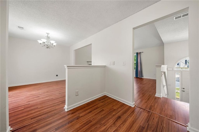 125 Fairhaven Trl, Fairburn, GA 30213 - unfurnished room featuring a textured ceiling, wood finished floors, a chandelier, plenty of natural light, and baseboards