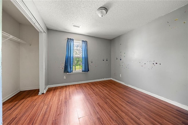 125 Fairhaven Trl, Fairburn, GA 30213 - unfurnished bedroom with wood finished floors, a textured ceiling, a closet, and baseboards