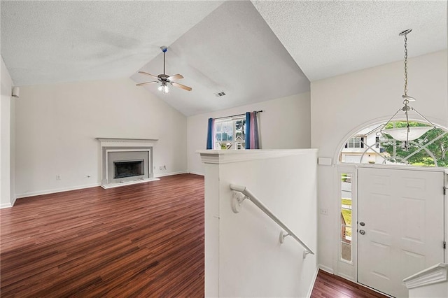125 Fairhaven Trl, Fairburn, GA 30213 - entrance foyer featuring plenty of natural light, dark wood finished floors, lofted ceiling, ceiling fan, and a fireplace with raised hearth