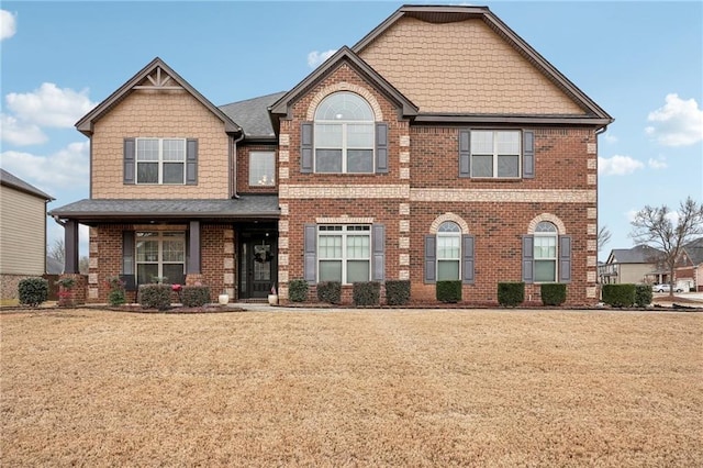 craftsman house featuring a front lawn and brick siding