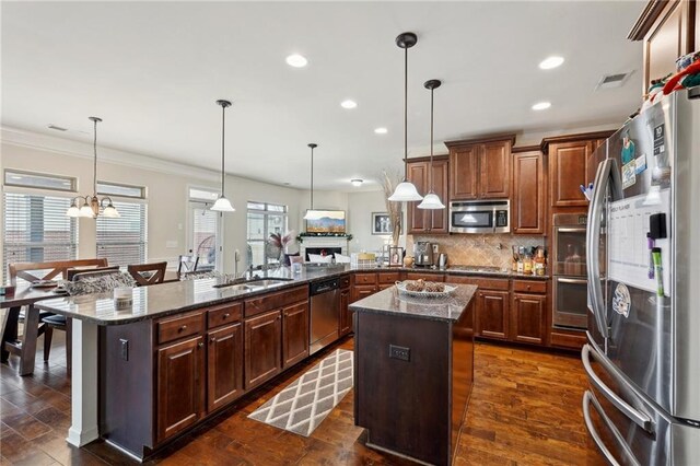 kitchen with pendant lighting, stainless steel appliances, and a center island