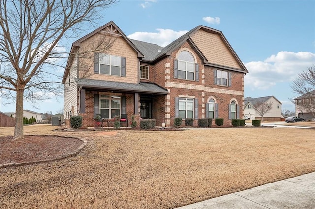 craftsman house featuring a front lawn, central AC, and brick siding