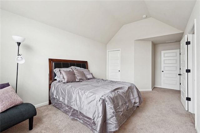 bedroom with vaulted ceiling, baseboards, and light colored carpet