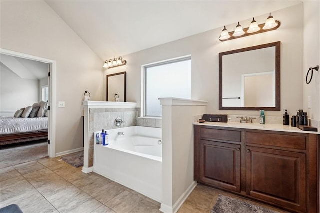 ensuite bathroom featuring connected bathroom, plenty of natural light, vaulted ceiling, and a bath