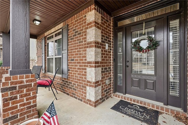 view of exterior entry featuring brick siding