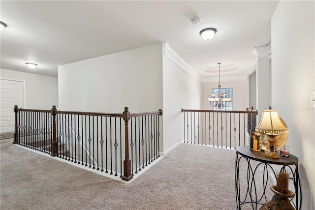 hallway with carpet floors, a chandelier, and crown molding