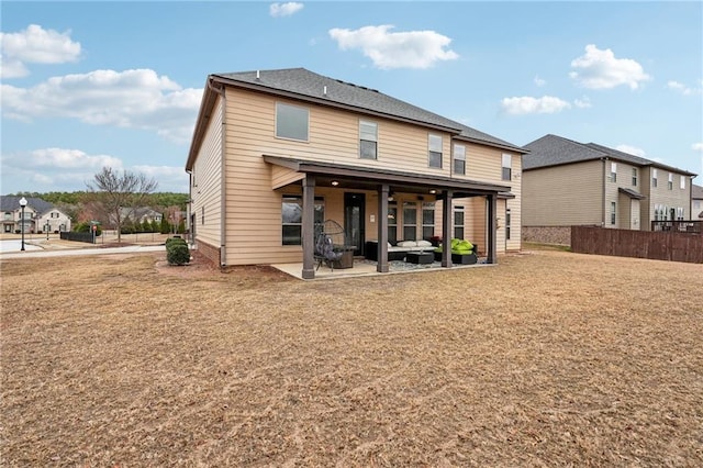 rear view of house with a yard, a residential view, a patio, and fence