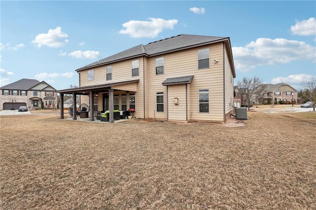 back of house with a residential view, a patio area, a lawn, and central air condition unit