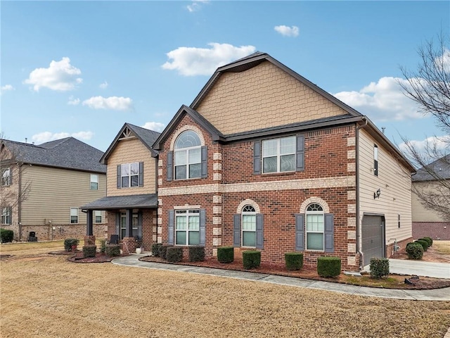 view of front of home with concrete driveway, brick siding, a front lawn, and an attached garage