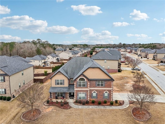 view of front of house featuring roof with shingles, a residential view, and brick siding