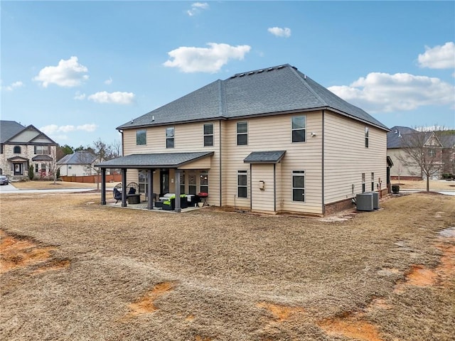 back of property featuring a patio area, a residential view, central AC unit, and roof with shingles