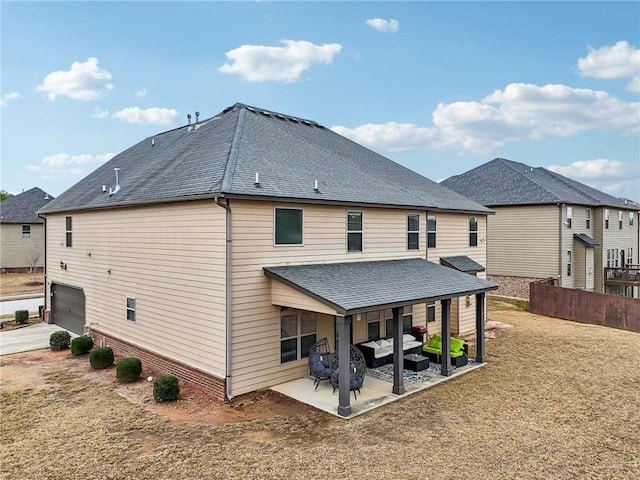 rear view of property featuring a shingled roof, a patio area, a lawn, and fence