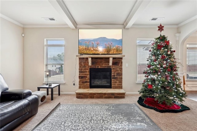 carpeted living area featuring a glass covered fireplace, visible vents, beamed ceiling, and baseboards