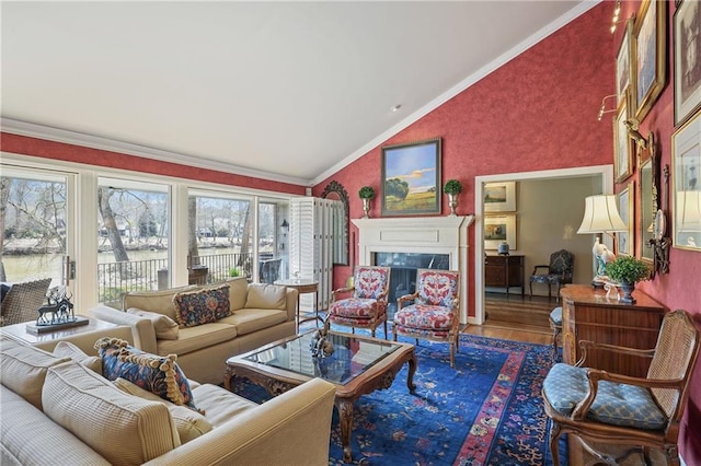 living room featuring a fireplace, ornamental molding, vaulted ceiling, and wood finished floors