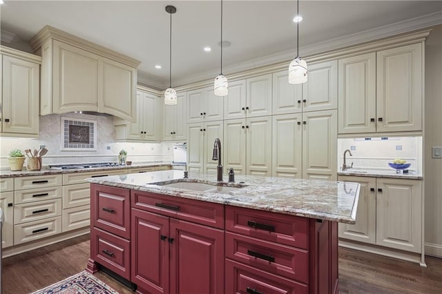 kitchen with hanging light fixtures, a center island with sink, stainless steel gas cooktop, and a sink