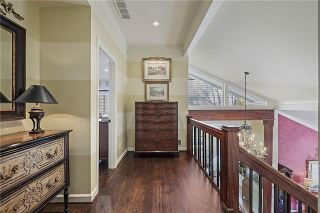 corridor with baseboards, dark wood finished floors, visible vents, crown molding, and a chandelier