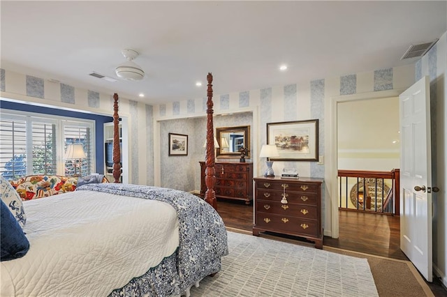 bedroom featuring wood finished floors, visible vents, and wallpapered walls