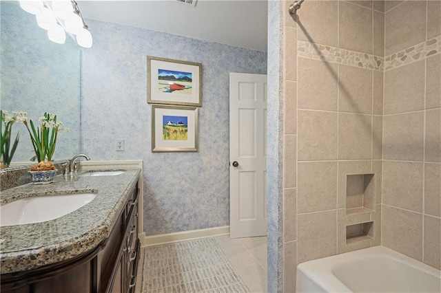 full bath featuring double vanity, wallpapered walls, baseboards, and a sink