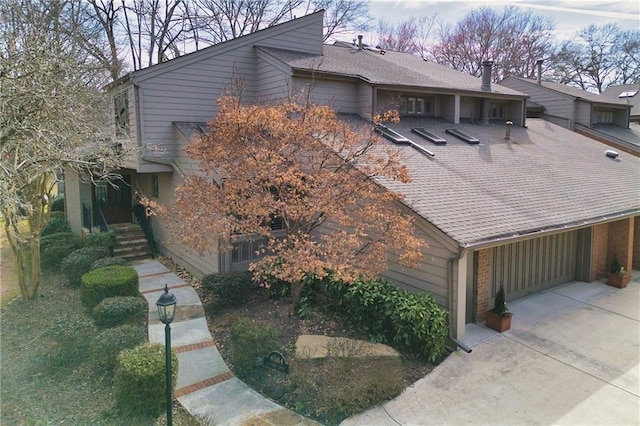 view of front of property featuring a shingled roof and brick siding