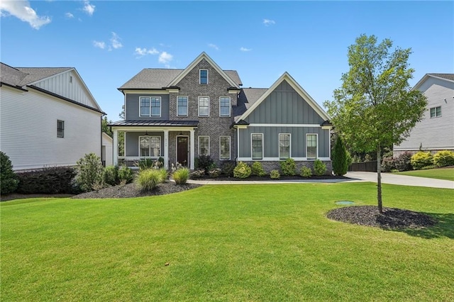 craftsman-style home featuring board and batten siding, a standing seam roof, a porch, and a front lawn