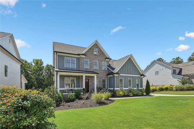 craftsman-style house featuring board and batten siding, a front yard, and covered porch