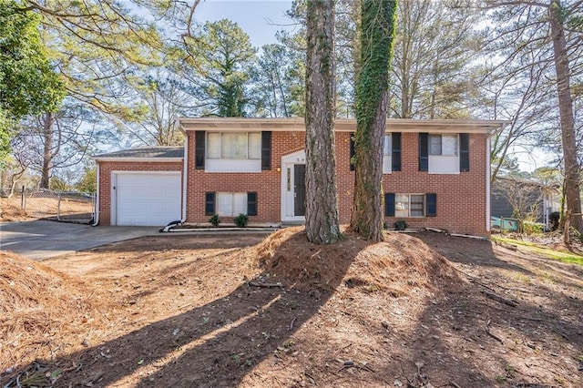 split foyer home featuring a garage, concrete driveway, and brick siding