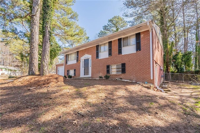 bi-level home featuring brick siding and fence