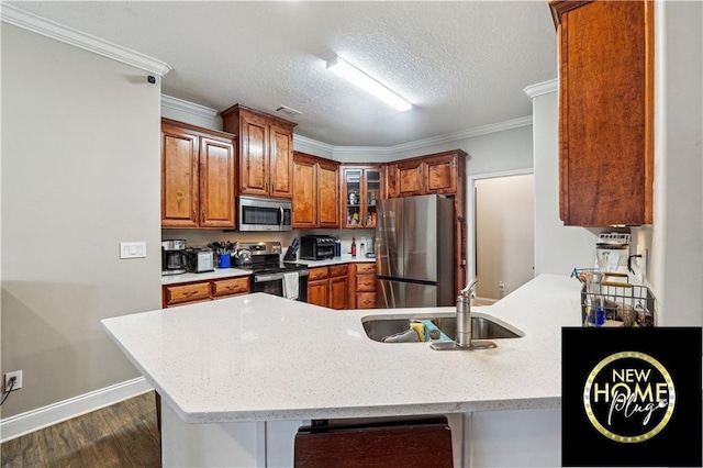 kitchen featuring appliances with stainless steel finishes, brown cabinetry, ornamental molding, a sink, and a peninsula