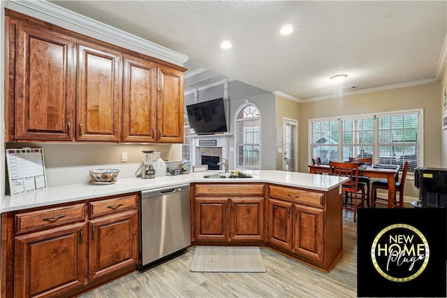 kitchen with a sink, a peninsula, ornamental molding, and stainless steel dishwasher